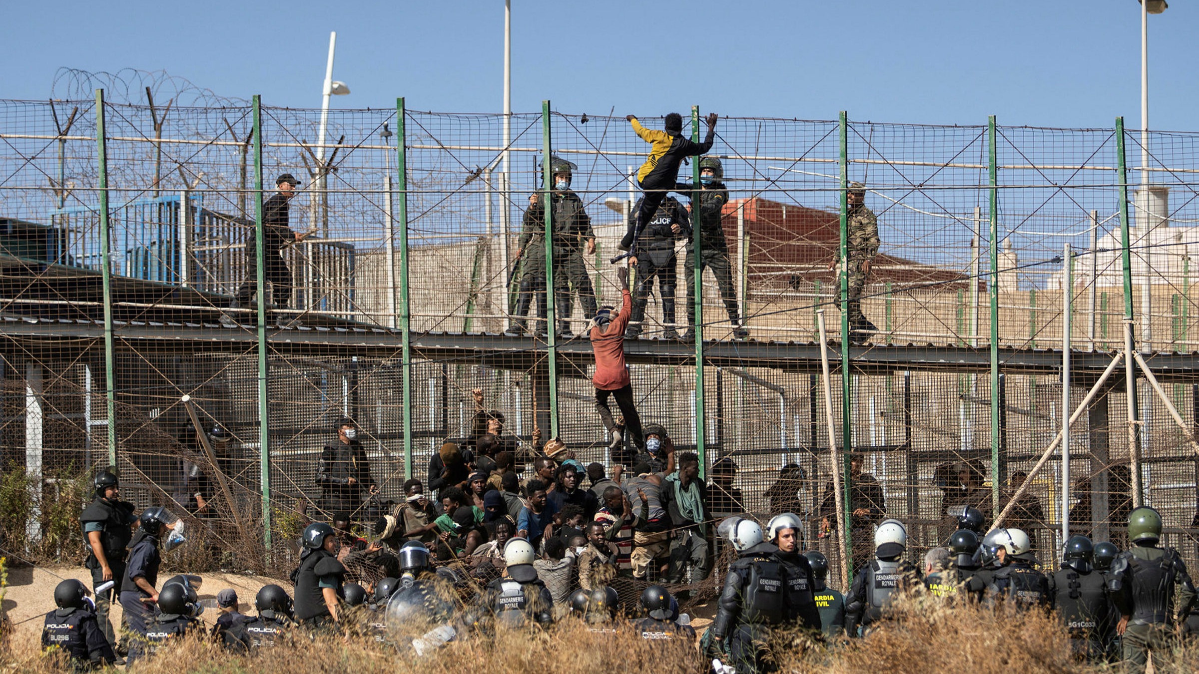 Migrants climbing the Border fence between Morocco and Melilla